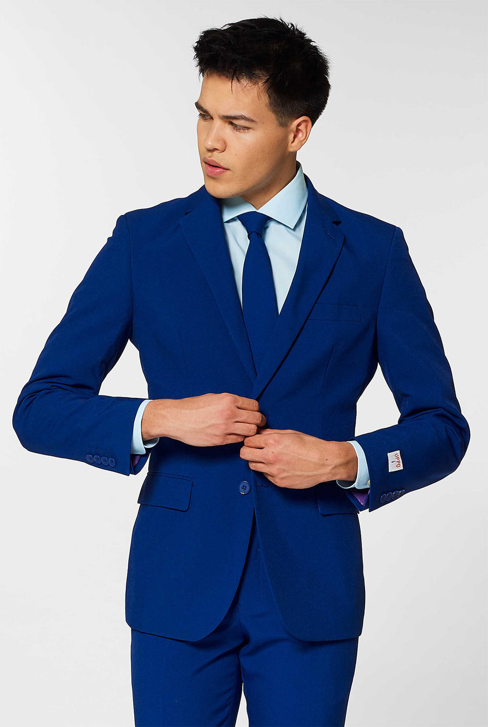 Video of man wearing Navy Royale, dark blue men's suit, showing suit like a model. Suit consists of blazer, pant and tie.