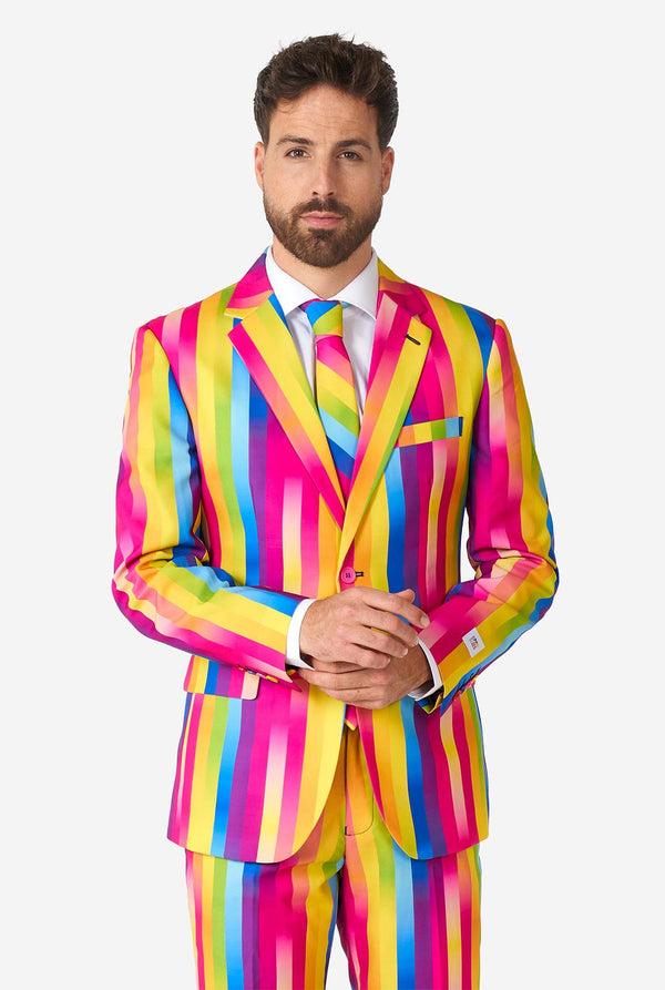 Video of man wearing Rainbow Glaze, rainbow colored men's suit, showing suit like a model. Suit consists of blazer, pant and tie.