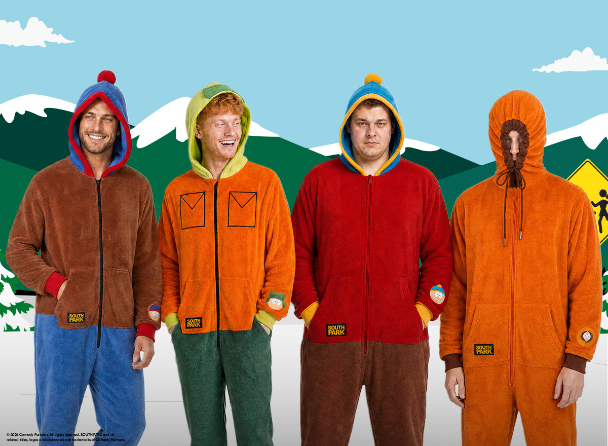 Four men wearing colorful South Park character onesies inspired by Stan, Kyle, Cartman, and Kenny, standing in front of a snowy South Park mountain backdrop.