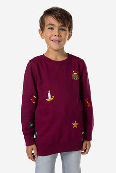 Kid wearing burgundy red Christmas sweater with colored Christmas icons