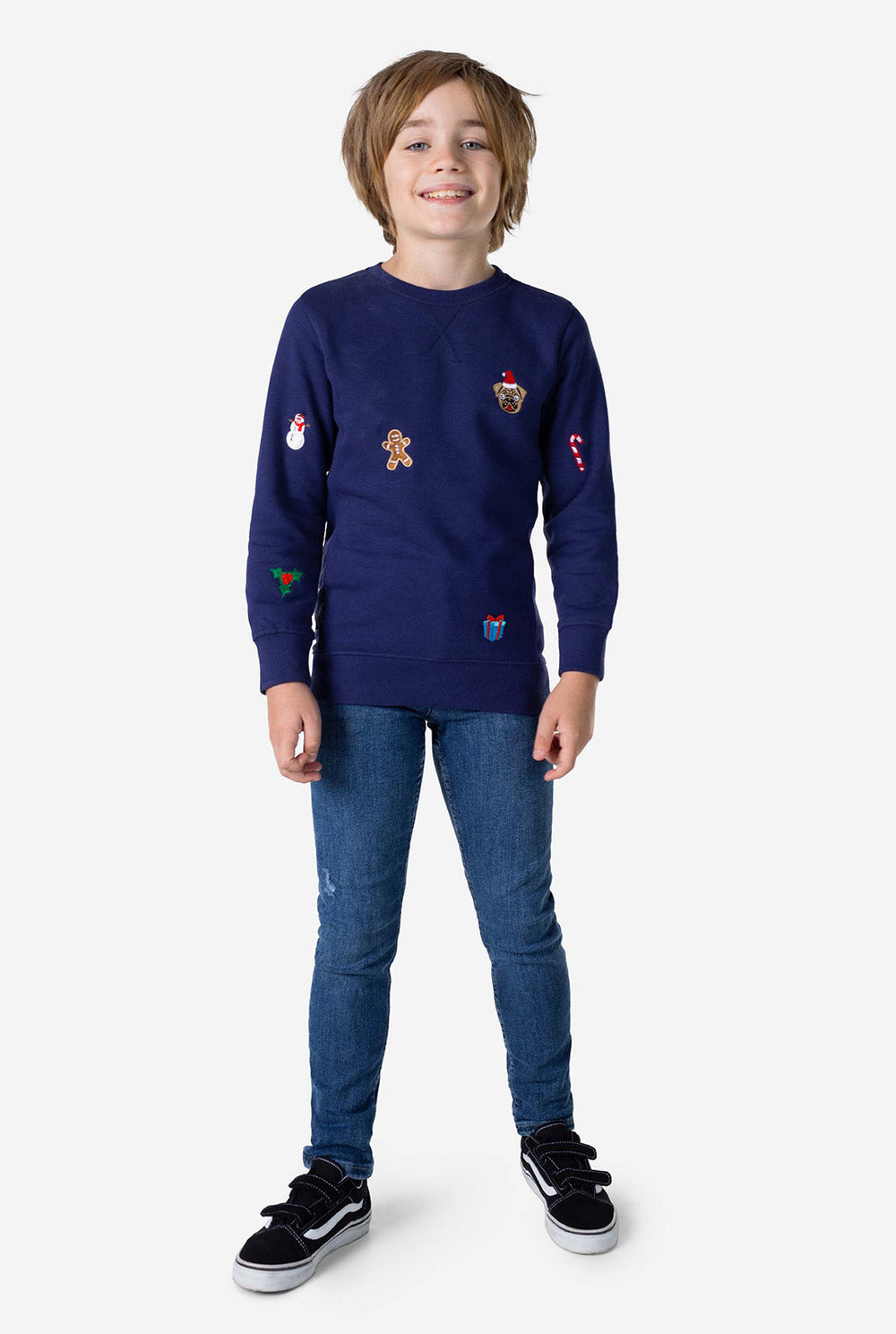 Kid wearing blue Christmas sweater with colored Christmas icons