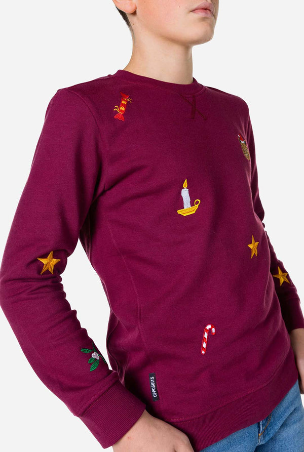 Kid wearing burgundy red Christmas sweater with Christmas icons