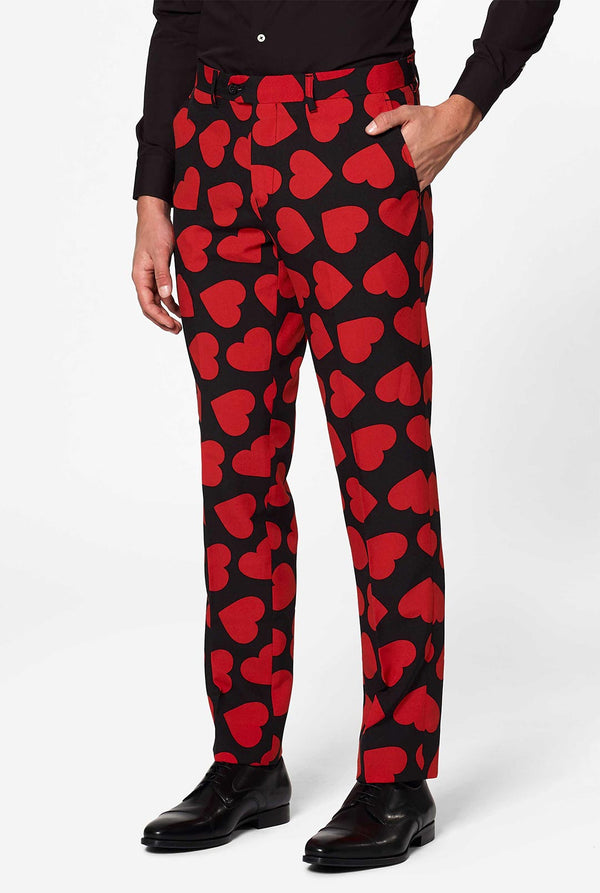 Man wearing black suit with red hearts print