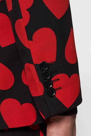 Man wearing black suit with red hearts print