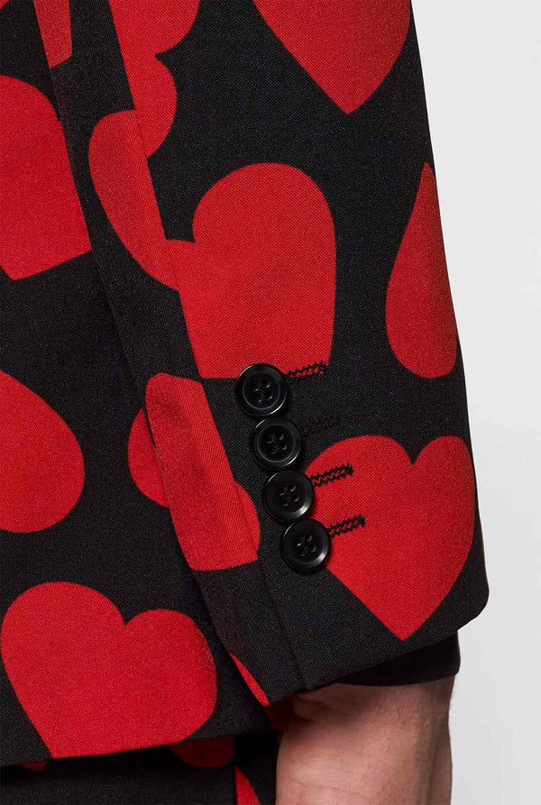 Man wearing black suit with red hearts print