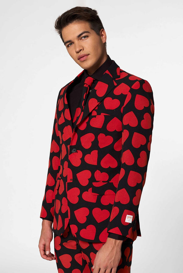 Man wearing black suit with red hearts print