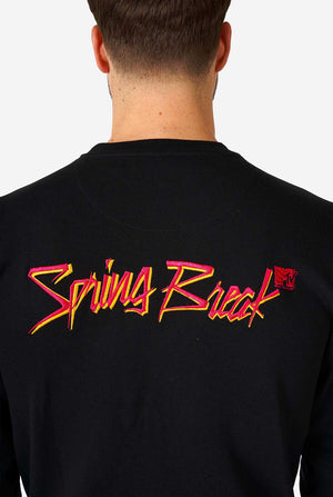 Man wearing black sweater with MTV embroidery.
