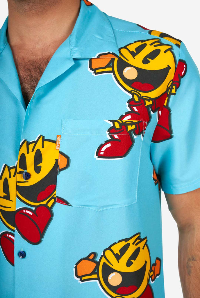 Man wearing blue summer shorts and shirt, with Pac-Man print