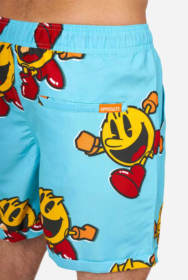 Man wearing blue summer shorts and shirt, with Pac-Man print